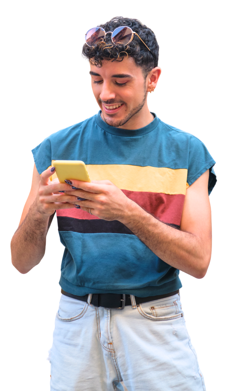 A young man using his phone and smiling.
